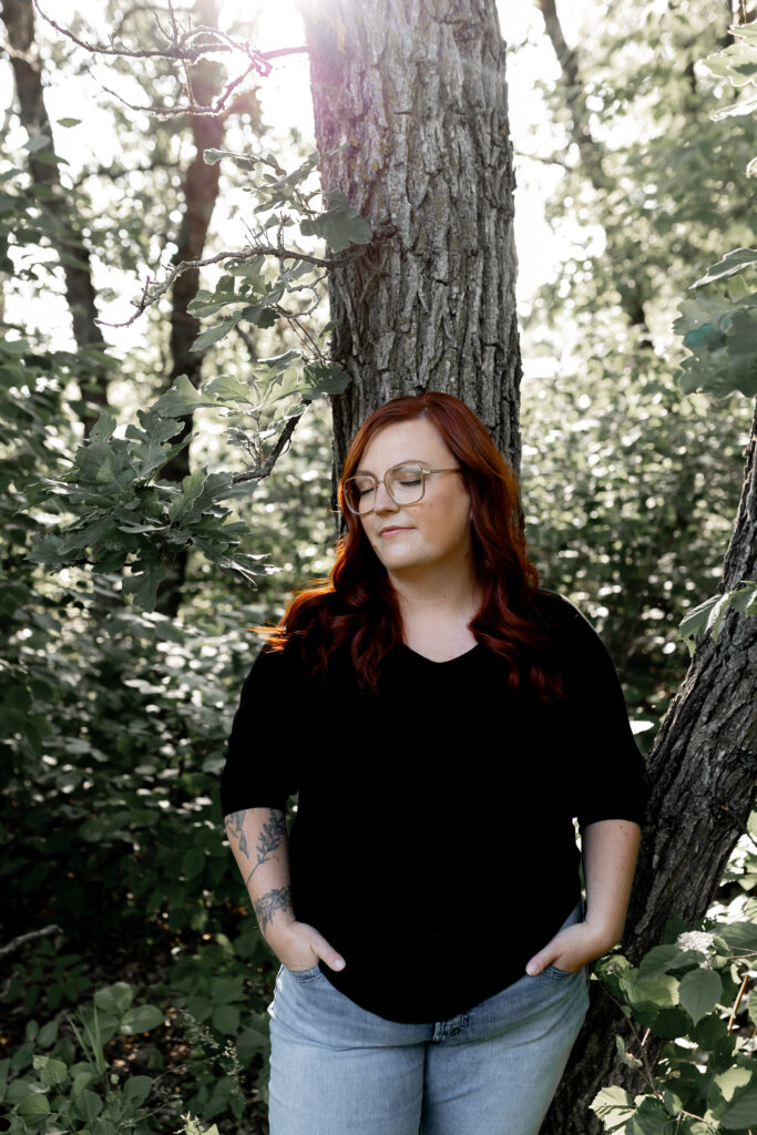 Red haired women leaning against an old oak tree