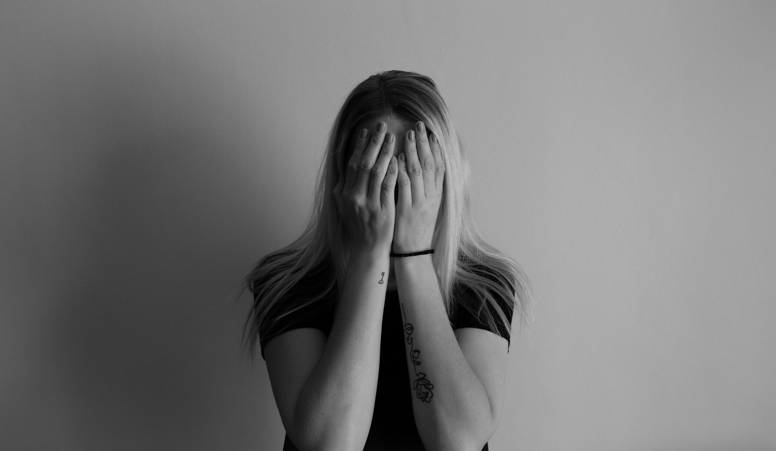Woman covering her face with her hands in black and white